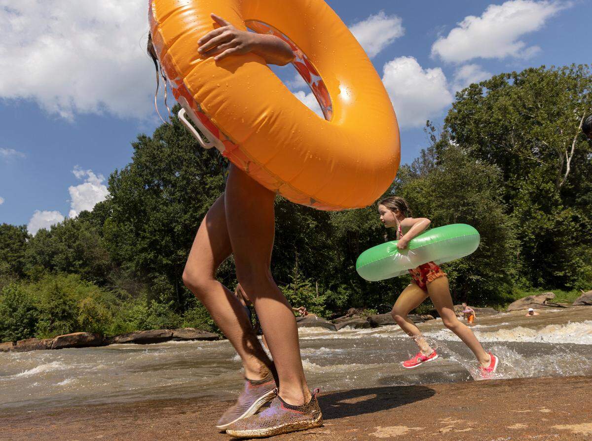 Olivia Propst, 7, right, runs back to ride the rapids once more at RiverPark at Cooleemee Falls on Saturday, Aug. 5, 2023, in Woodleaf, N.C.