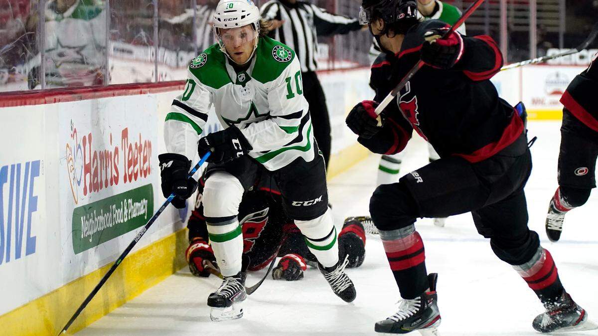 Dallas Stars center Ty Dellandrea (10) controls the puck while Carolina Hurricanes defenseman Haydn Fleury (4) defends during the first period of an NHL hockey game in Raleigh, N.C., Saturday, April 3, 2021. (AP Photo/Gerry Broome)
