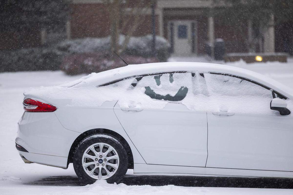A smiley face is drawn in snow on the window of a car parked in Chapel Hill on Saturday afternoon, Jan. 31, 2026, as a winter storm brings snow and freezing temperatures to the region.