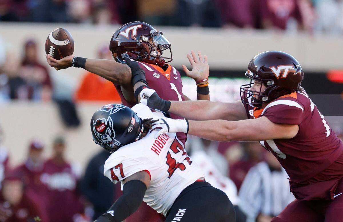 N.C. State defensive lineman Red Hibbler (47) gets his hand on Virginia Tech quarterback Kyron Drones (1), forcing a bad throw, during the first half of N.C. State’s game against Virginia Tech at Lane Stadium in Blacksburg, VA, Saturday, Nov. 18, 2023.