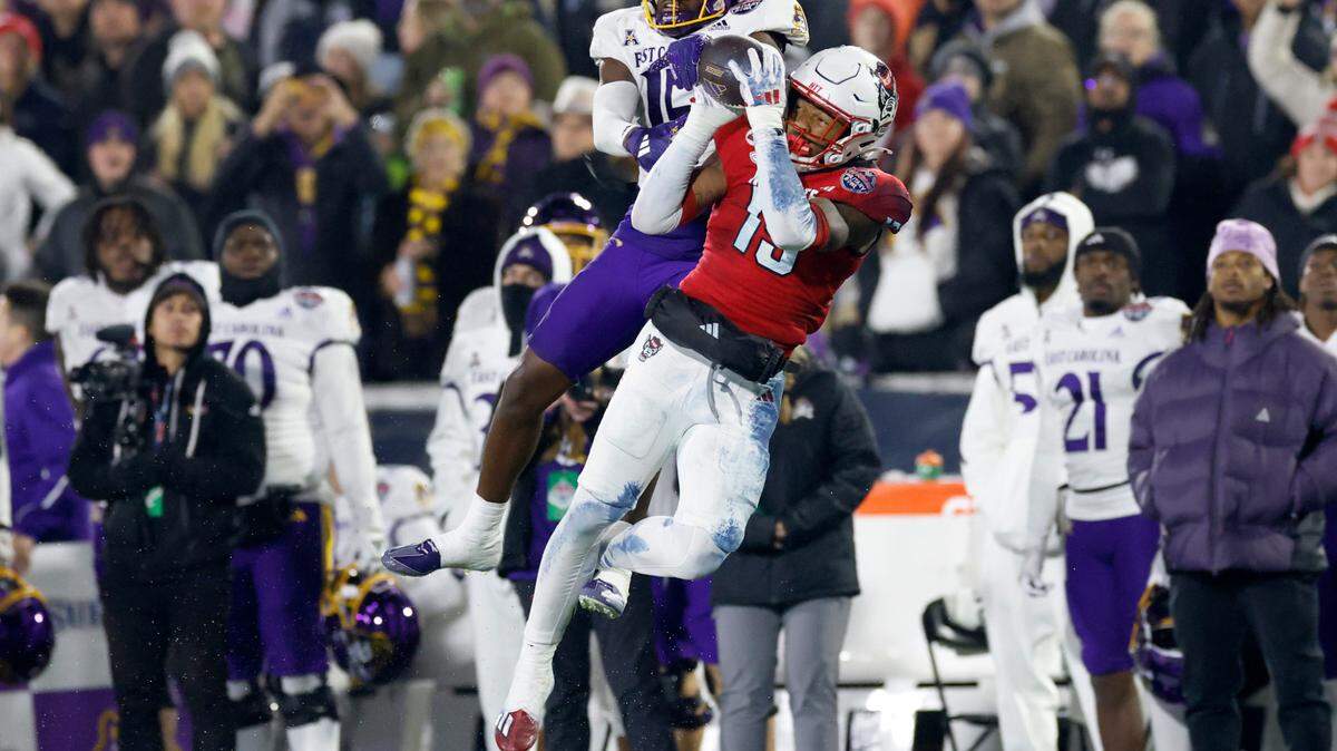 N.C. State cornerback Tamarcus Cooley (15) intercepts the ball intended for East Carolina wide receiver Yannick Smith (15) during the second half of ECU’s 26-21 victory over N.C. State in the Military Bowl at Navy-Marine Corps Memorial Stadium in Annapolis, Md., Saturday, Dec. 28, 2024.