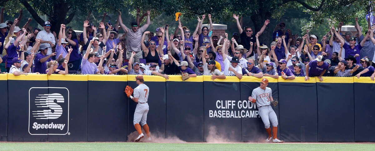 East Carolina fans celebrate after East Carolina’s Alec Makarewicz hit a homerun in the bottom of the eighth that went off the glove of Texas’ Douglas Hodo (7) during ECUís 13-7 victory over Texas in the Greenville Super Regional at Clark-LeClair Stadium Friday, June 10, 2022. Texasí Eric Kennedy (30) is to the right.
