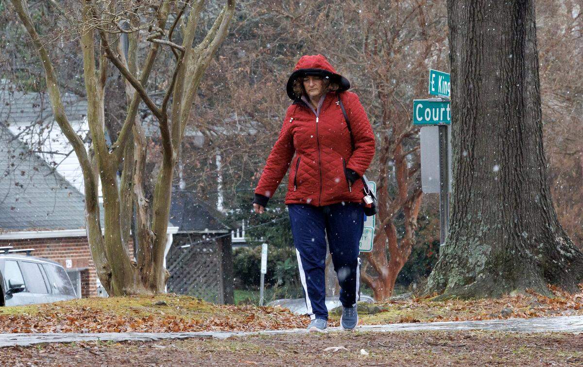 A person walks through downtown Hillsborough as light snow falls on Monday, Dec. 8, 2025.