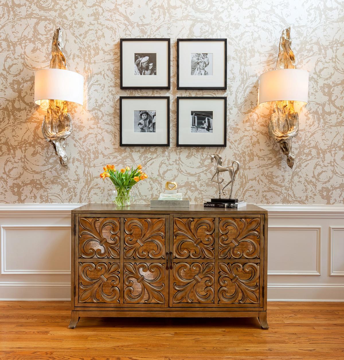 The swirly modern wallpaper in a neutral color palette adds the wow effect thatwas missing in this two-story modern foyer.