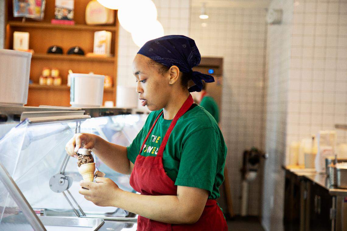 Saqqara Woody, an ambassador at Jeni’s in downtown Durham’s Brightleaf Square, scoops ice cream in the shop on Wednesday, June 8, 2022.