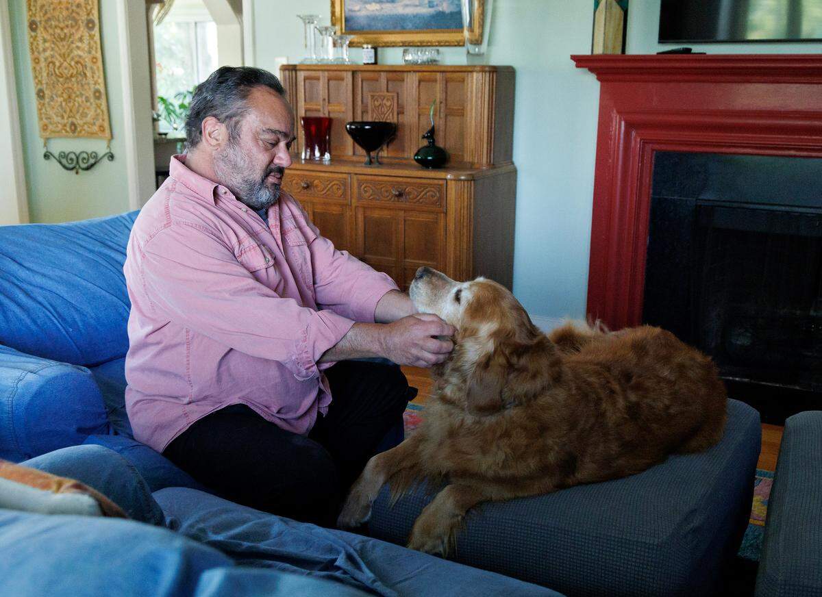 Durham resident Marcelo Levy sits with his seven-year-old Golden Retriever, Mensch, at his home on Thursday, April 10, 2025. He says he worries how the policies of the Trump administration will affect his life.