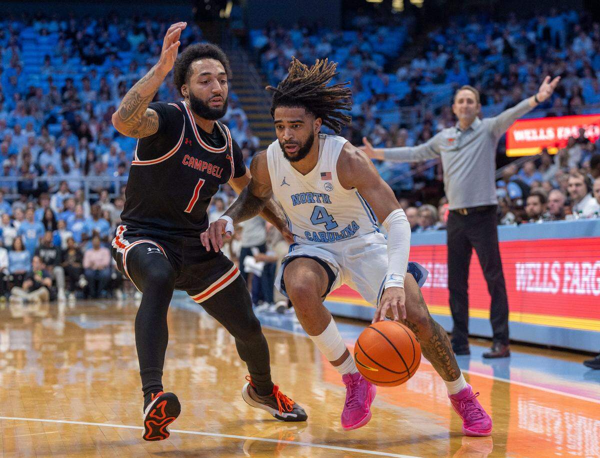 Campbells’ Taos Cook (1) defends North Carolina guard R.J. Davis (4) in the first half on Sunday, December 29, 2024 at the Smith Center in Chapel Hill, N.C.
