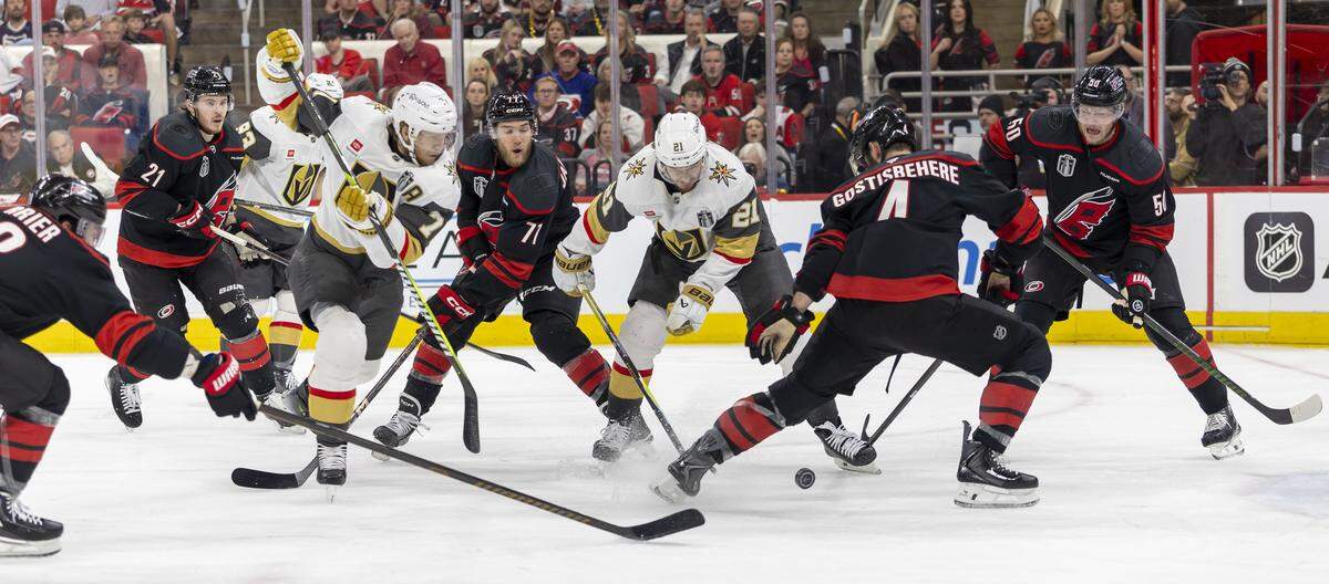 Las Vegas center Brett Howden (21) and Carolina Hurricanes defenseman Shayne Gostisbehere (4) battle for control of the puck in front of the Knights’ goal in the second period, during Game 1 of the Stanley Cup Finals, on Tuesday, June 2, 2026 at Lenovo Center in Raleigh, N.C.