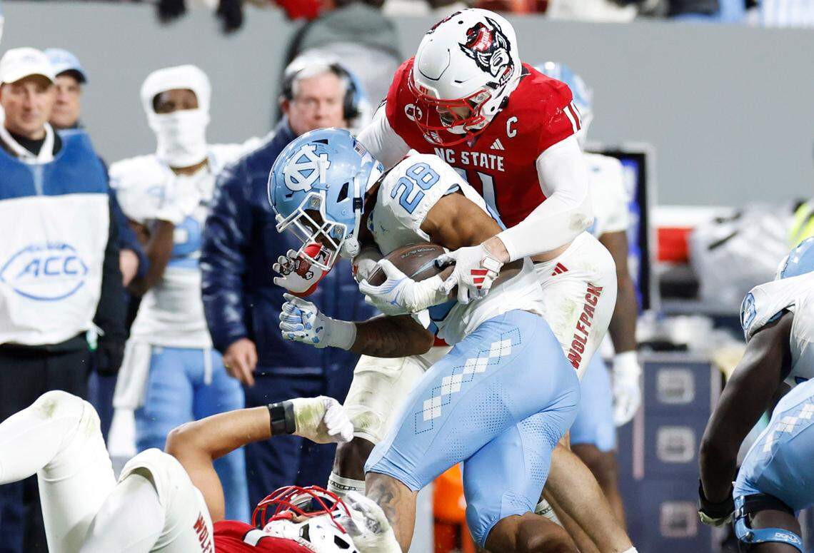 N.C. State linebacker Payton Wilson (11) tackles North Carolina running back Omarion Hampton (28) during the second half of N.C. State’s 39-20 victory over UNC at Carter-Finley Stadium in Raleigh, N.C., Saturday, Nov. 25, 2023.