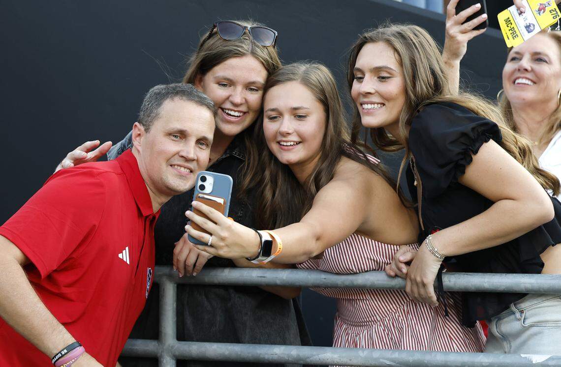 Fans take photos with N.C. State basketball coach Will Wade before N.C. State’s game against ECU at Carter-Finley Stadium in Raleigh, N.C., Thursday, August 28, 2025.