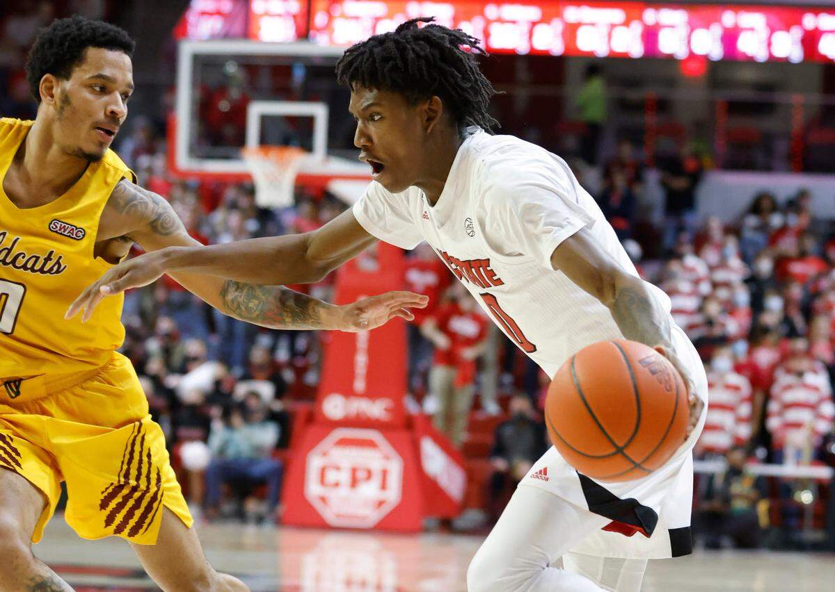 N.C. State’s Terquavion Smith (0) looks to drive around Bethune-Cookman’s Mikey West (0) during the second half of N.C. State’s 65-48 victory over Bethune-Cookman University at Reynolds Coliseum in Raleigh, N.C., Thursday, December 9, 2021.