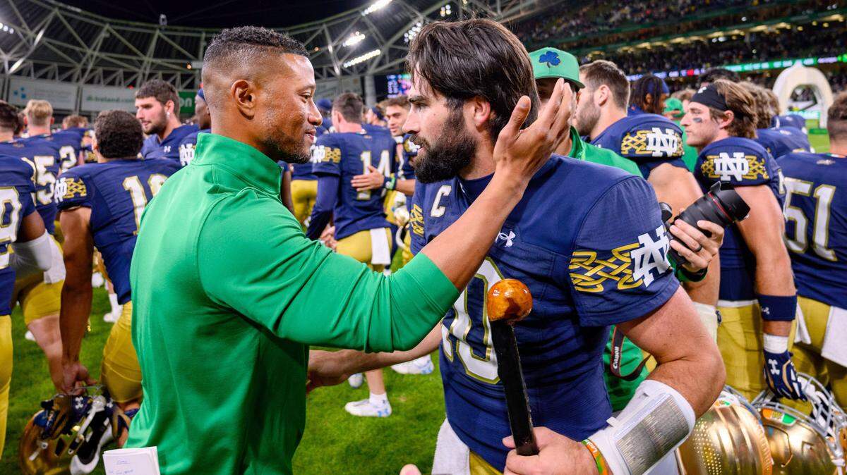 Notre Dame Fighting Irish head coach Marcus Freeman, left, celebrates with quarterback Sam Hartman (10) after Notre Dame defeated the Navy Midshipmen 42-3 at Aviva Stadium.