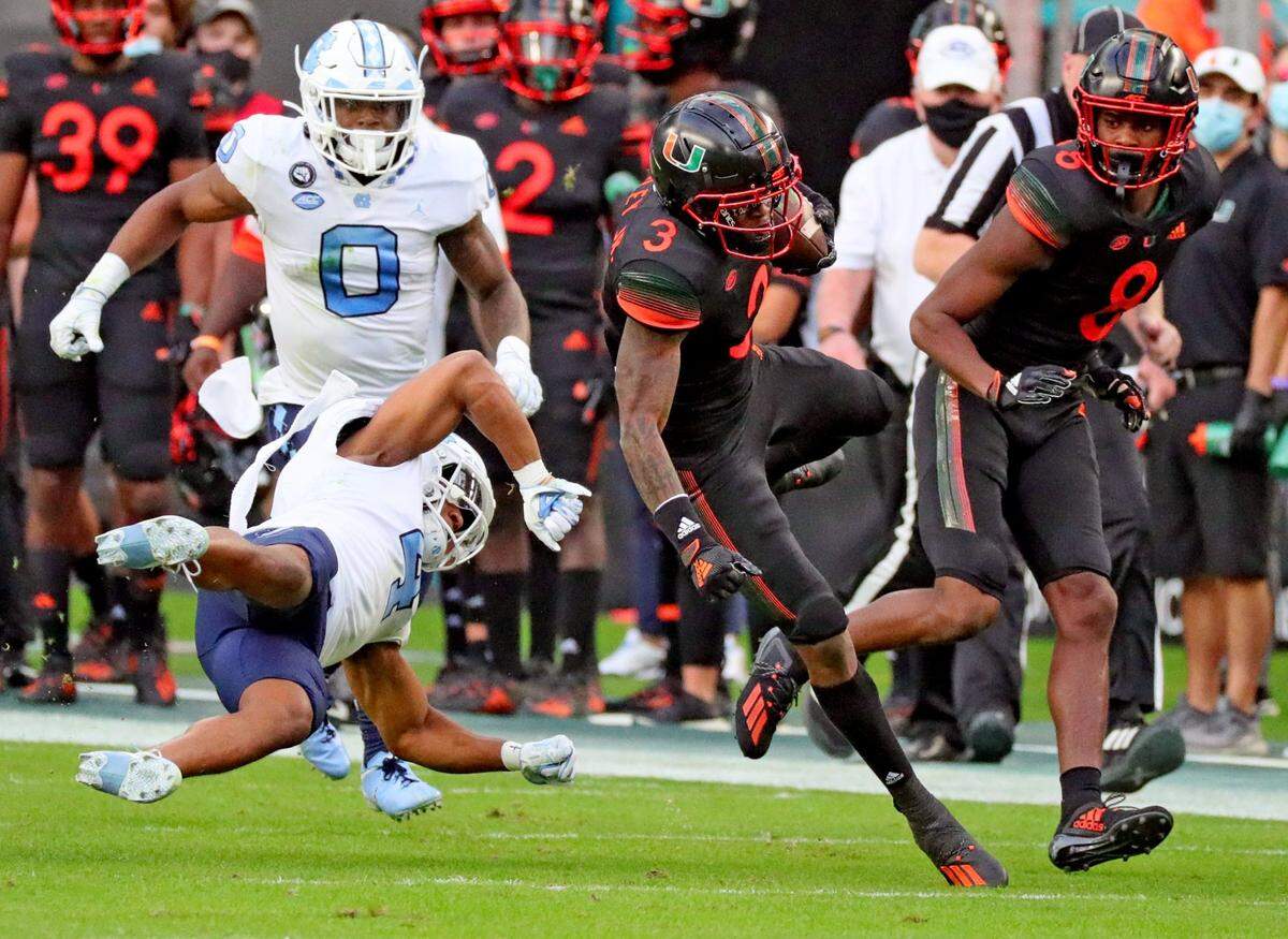 Miami Hurricanes wide receiver Mike Harley (3) catches the ball as North Carolina Tar Heels defensive back Trey Morrison (4) gets horizontal in the first quarter at Hard Rock Stadium In Miami Gardens, Florida, Saturday, December 12, 2020.