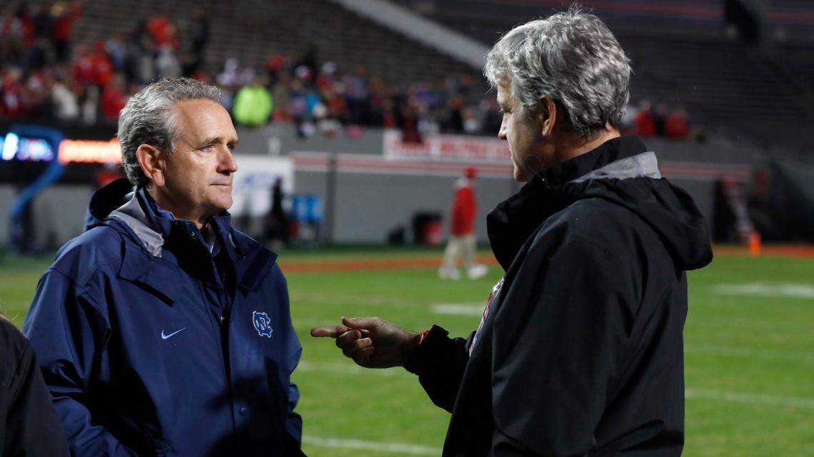 UNC Athletic Director Bubba Cunningham, left, talks with N.C. State Athletic Director Boo Corrigan before N.C. State’s game against North Carolina at Carter-Finley Stadium in Raleigh, N.C., Saturday, November 30, 2019.
