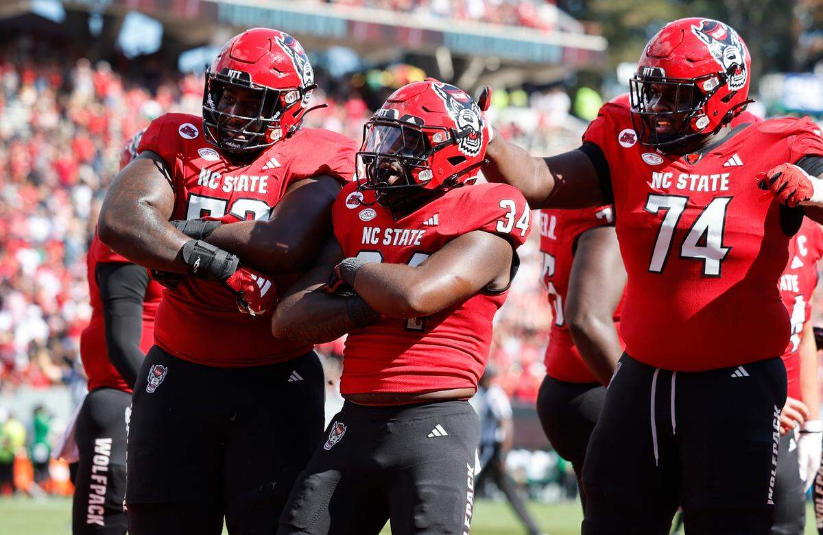 N.C. State offensive lineman Derrick Eason (53), running back Delbert Mimms III (34) and offensive lineman Anthony Belton (74) celebrate Mimms’ 18-yard touchdown run during the first half of N.C. State’s game against Marshall at Carter-Finley Stadium in Raleigh, N.C., Saturday, Oct. 7, 2023.
