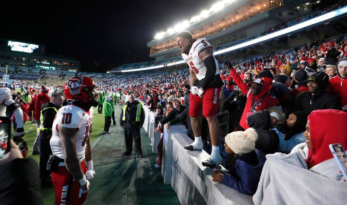 N.C. State’s DK Kaufman (5) celebrates with KC Concepcion (10) after the Wolfpack’s 35-30 victory over UNC at Kenan Stadium in Chapel Hill, N.C., Saturday, Nov. 30, 2024.