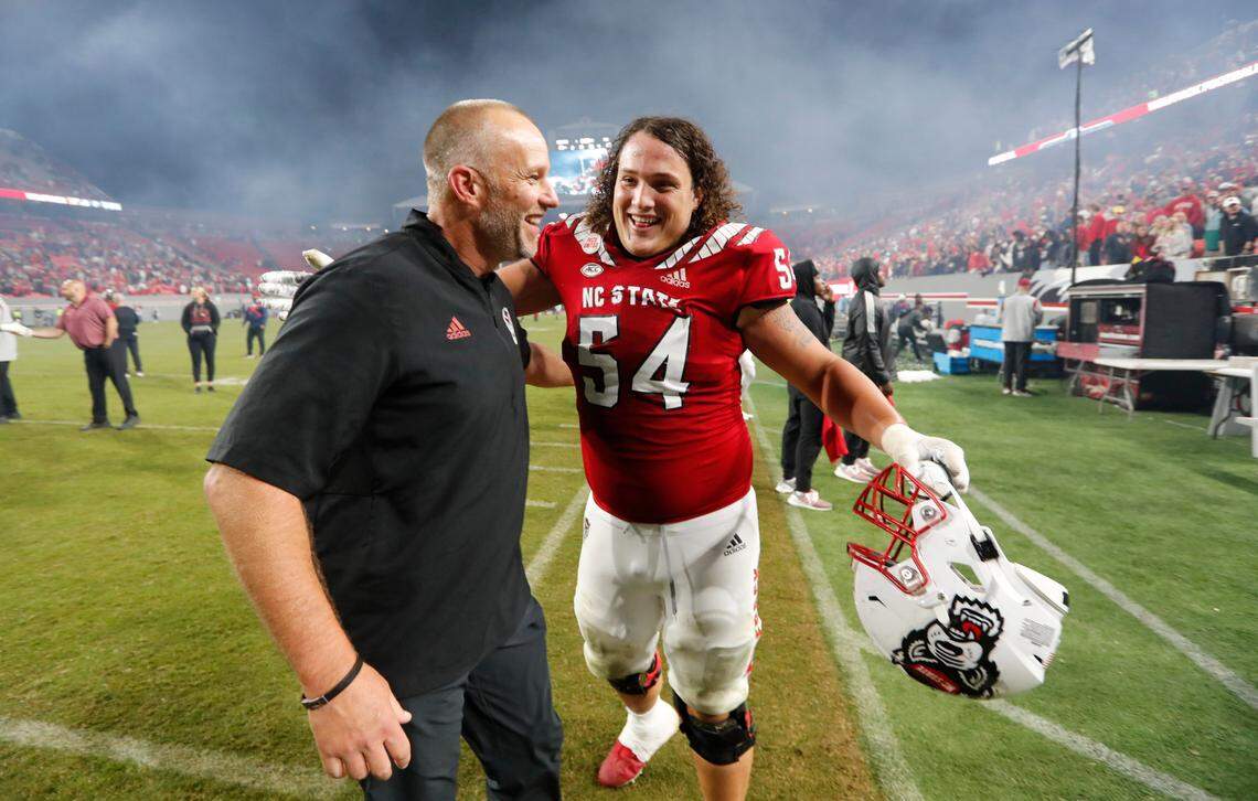N.C. State head coach Dave Doeren and offensive lineman Dylan McMahon (54) hug after N.C. State’s 19-17 victory over Florida State at Carter-Finley Stadium in Raleigh, N.C., Saturday, Oct. 8, 2022.