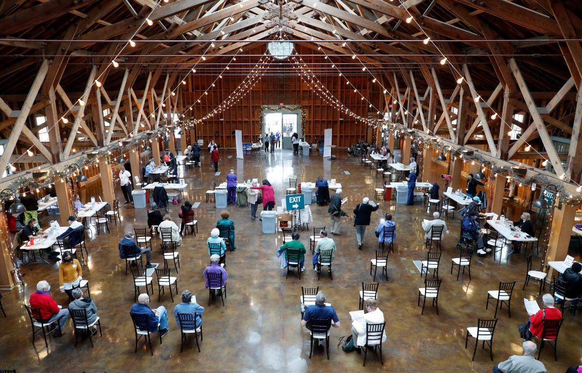 Attendees sit and wait for 15 minutes after getting their vaccine shot during a COVID-19 vaccination clinic administered by FirstHealth of the Carolinas at the Fair Barn in Pinehurst, N.C., Tuesday, January 26, 2021.