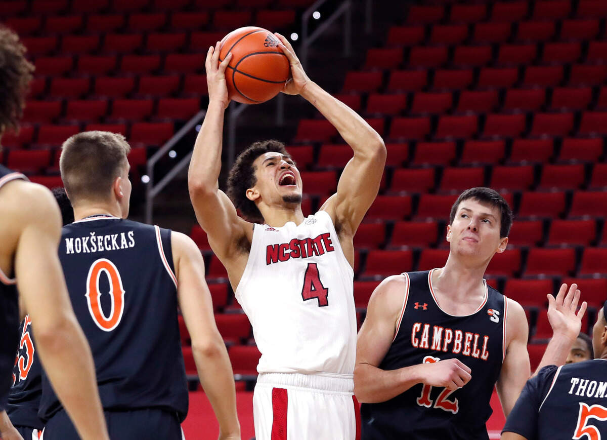 N.C. State’s Jericole Hellems (4) shoots as Campbell’s Gediminas Mokseckas (0) and Jesus Carralero (12) defend during the second half of N.C. State’s 69-50 victory over Campbell at PNC Arena in Raleigh, N.C., Saturday, Dec. 19, 2020.