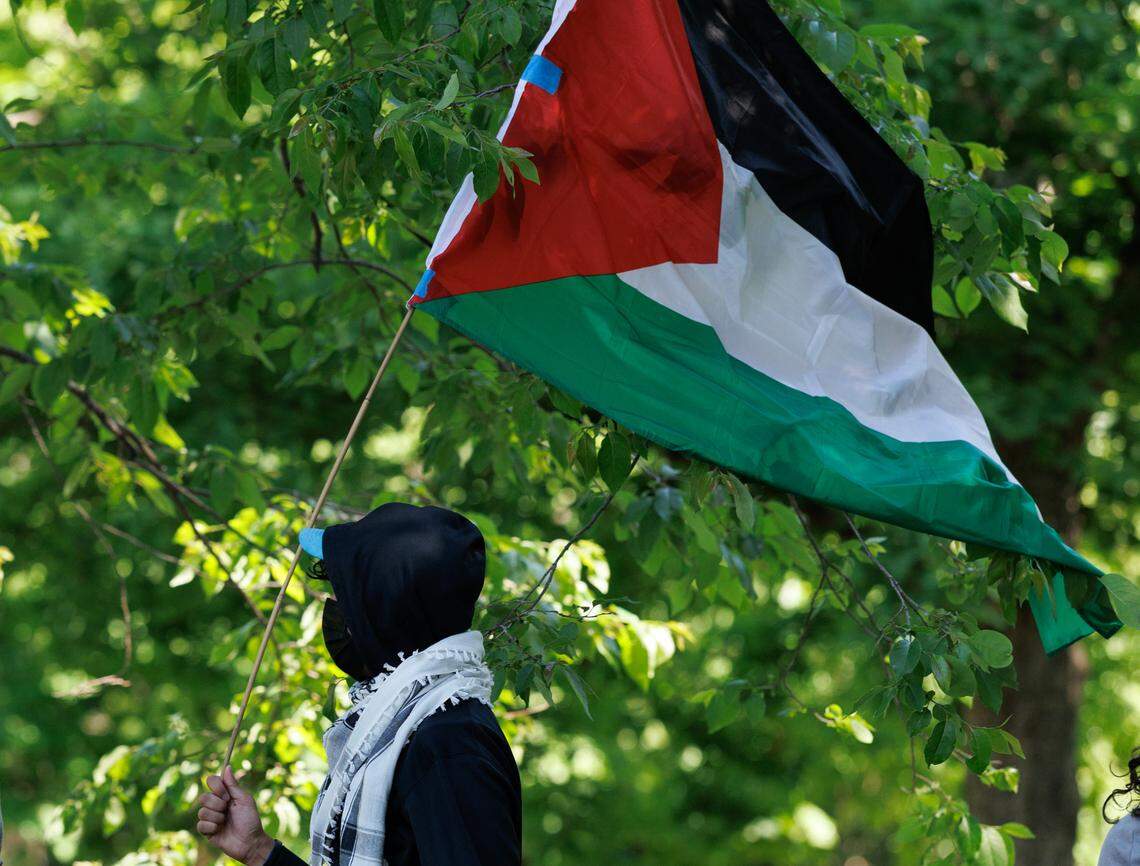 A person holds a Palestinian flag as demonstrators gather on UNC-Chapel Hill’s Polk Place on the anniversary of the tent encampment at UNC-Chapel Hill on Tuesday, April 29, 2025.