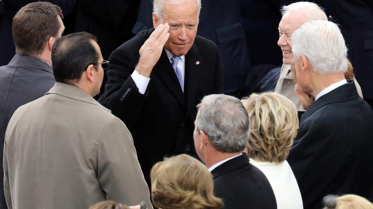 Vice President Joe Biden salutes toward former President George W. Bush.