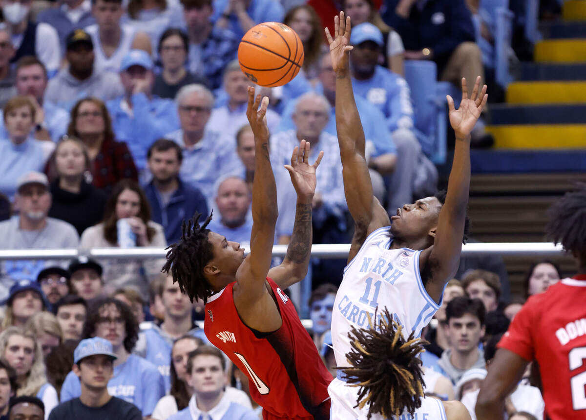 N.C. State’s Terquavion Smith (0) shoots as North Carolina’s D’Marco Dunn (11) defends during the first half of N.C. State’s game against UNC at the Smith Center in Chapel Hill, N.C., Saturday, Jan. 21, 2023.