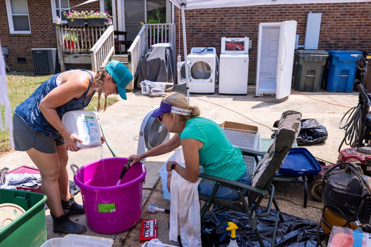 Heather Jacobson, left, and her mother, Sandy Jacobson, begin sorting, washing and salvaging belongings at Heather’s home in Durham’s Old Farm neighborhood near the Eno River on Wednesday, July 9, 2025, after flash flooding caused by Tropical Storm Chantal.