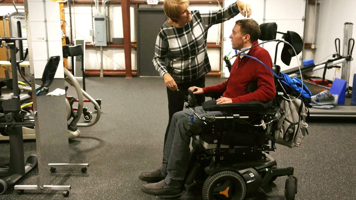 Karen Thor, left, helps her son, Michael Thor, right, fix his hair after a therapy session at Next Step Raleigh on Dec. 6, 2018. Karen Thor opened the local franchise of the non-profit physical therapy chain NextStep, enabling Michael to come home from Atlanta and work out multiple times per week.