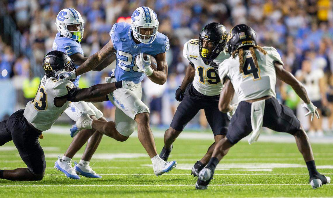 North Carolina running back Omarion Hampton (28) looks for running room against Appalachian State’s Derrell Farrar (33) on a 7-yard carry in overtime on Saturday September 9, 2023 at Kenan Stadium in Chapel Hill, N.C