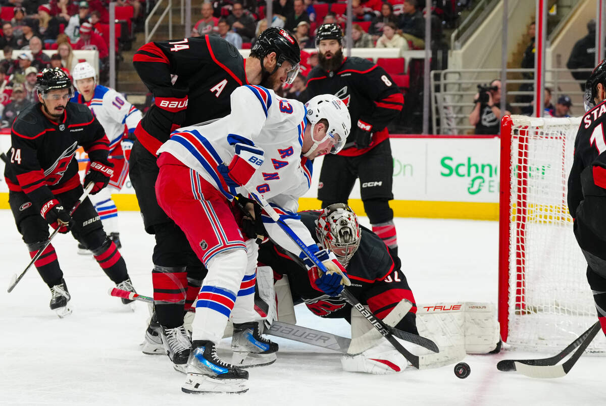 Carolina Hurricanes goaltender Pyotr Kochetkov (52) with defenseman Jaccob Slavin (74) stops the scoring attempt by New York Rangers left wing Alexis Lafrenire (13) during the second period at Lenovo Center.