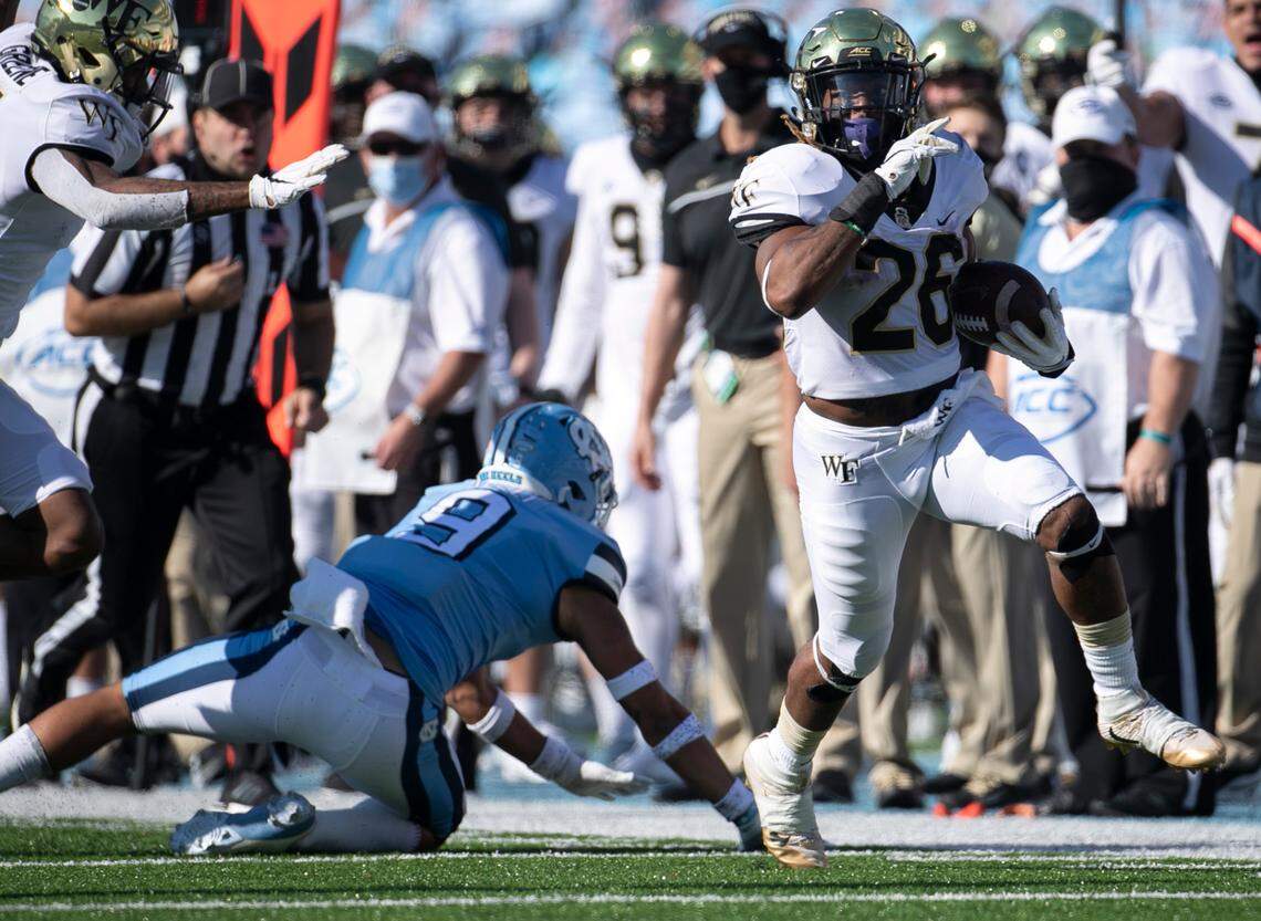 Wake Forest’s Christian Beal-Smith (26) picks up 14 yards in the first quarter ahead of North Carolina’s Cam’Ron Kelly (9) at Kenan Stadium on Saturday, November 14, 2020 in Chapel Hill, N.C.