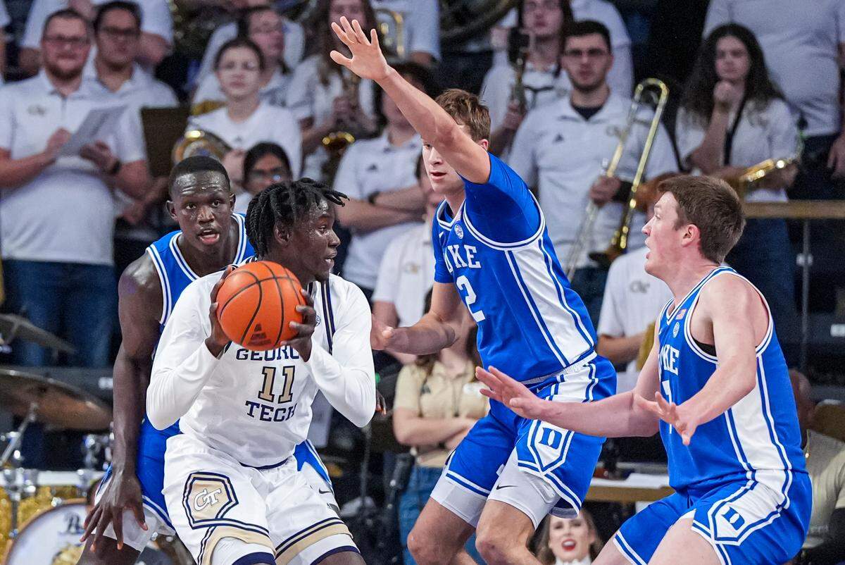 Georgia Tech Yellow Jackets forward Baye Ndongo (11) looks to pass against Duke Blue Devils guard Cooper Flagg (2) and guard Kon Knueppel (7) during the first half at McCamish Pavilion.