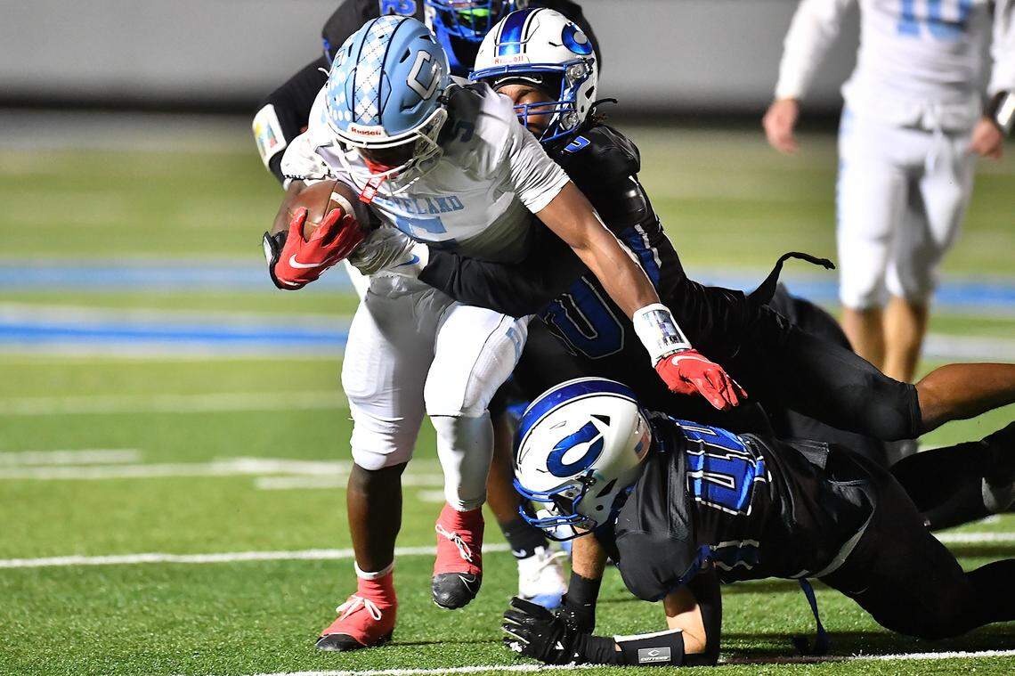 Cleveland running back Porter Bennett (5) runs for yardage against Clayton's Malachi Burt (20) and Mason Bucklad (44) during the first half. The Cleveland Rams took on the Clayton Comets in a conference football game in Clayton, N.C. on October 31st in Clayton, N.C.