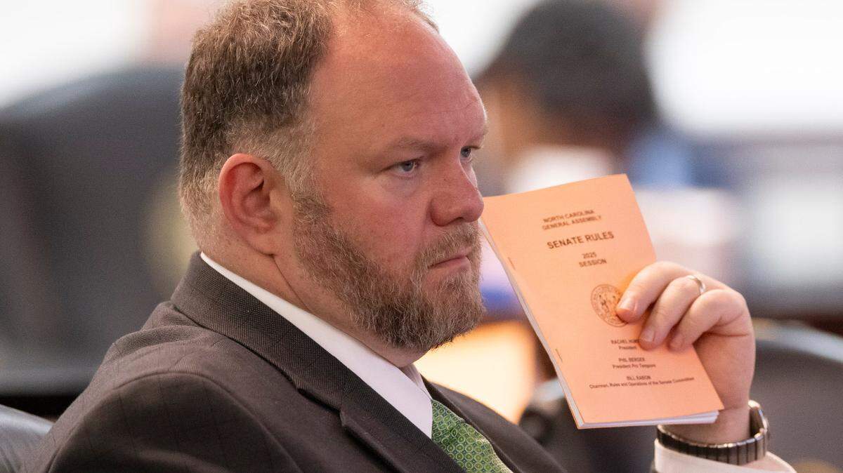Senator Ralph Hise clutches the Senate Rules book as he listens to Democratic members offering amendments to the Senate budget proposal on Wednesday, April 16, 2025 at the General Assembly in Raleigh, N.C.
