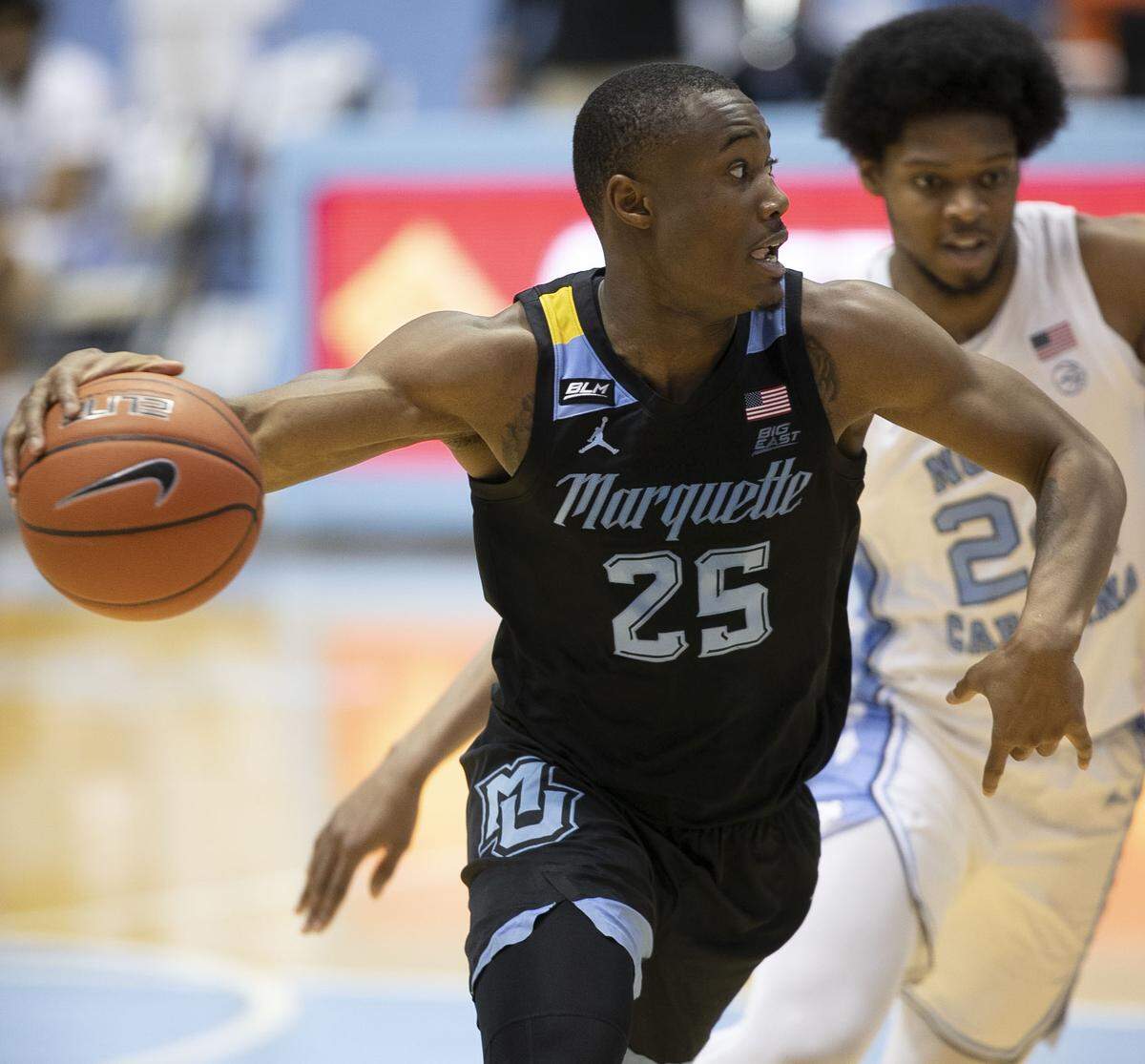 Marquette’s Koby McEwen (25) drives to the basket against North Carolina’s Kerwin Walton (24) during the second half on Wednesday, February 24, 2021 at the Smith Center in Chapel Hill, N.C.