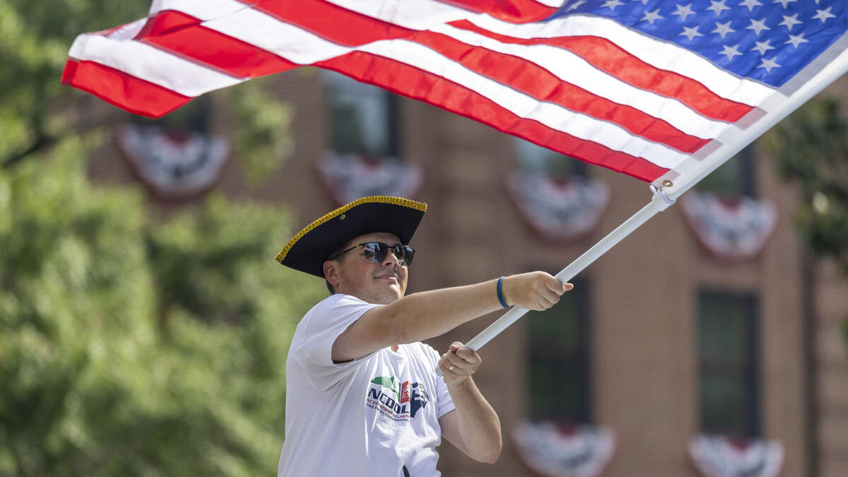 David Capen, from the North Carolina Department of Labor, waves the American flag during the First in Freedom Parade on Saturday, July 4, 2026, in Raleigh.