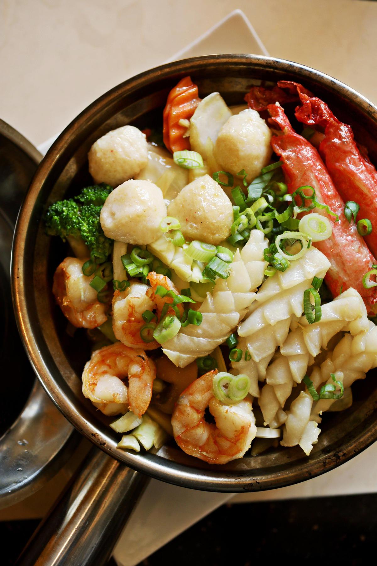 The clay pot rice is served with mixed seafood and vegetables over rice in a not-too-sweet caramel sauce at Pho Happiness in Chapel Hill.