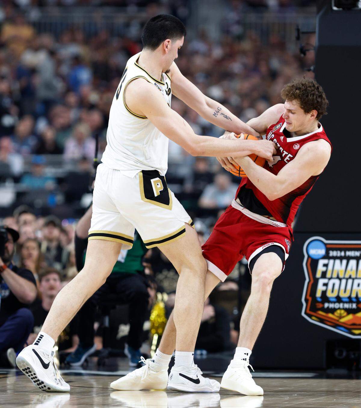 NC State’s Ben Middlebrooks ties up the ball against Purdue’s Zach Edey in second half action of their Final Four game, Saturday, April 6, 2024.