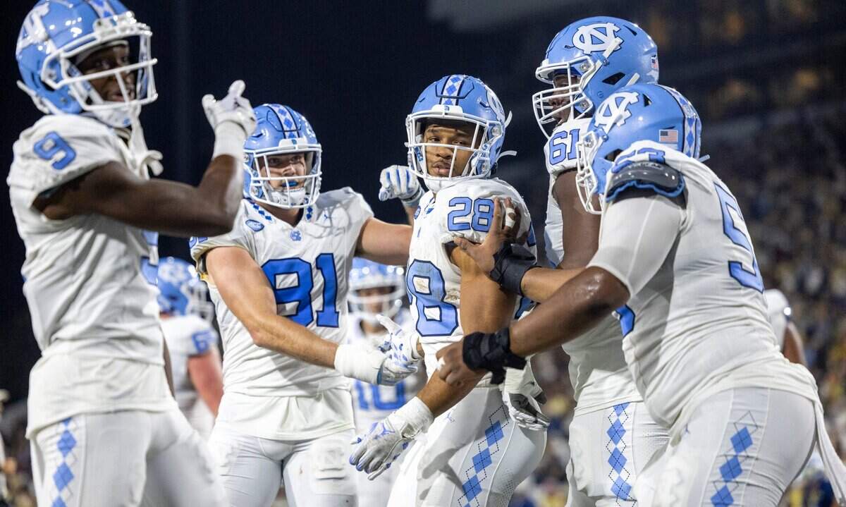 North Carolina’s Omarion Hampton (28) is surrounded by teammates after scoring on a three-yard run to give the Tar Heels’ a 28-21 lead in the second quarter on Saturday, October 28, 2023 at Bobby Dodd Stadium in Atlanta, Georgia.