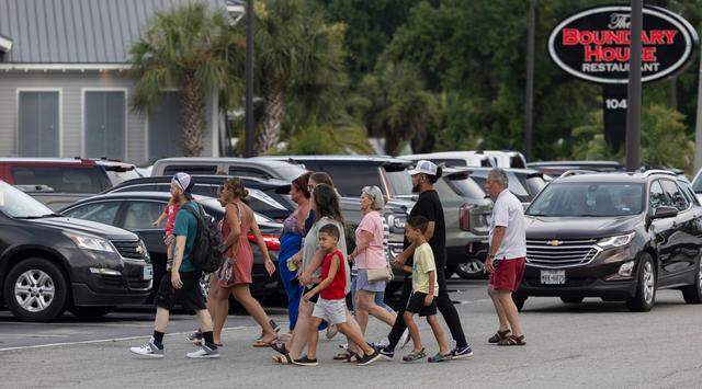 Vacationeers and visitors to Calabash, N.C. cross River Road, to shop at Callahan’s or visit any one of the many restaurants that line the street on Thursday, June 27, 2024 in Calabash, N.C.