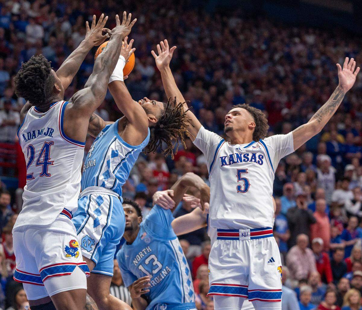 Kansas forward K.J. Adams Jr. (24) and guard Zeke Mayo (5) defend North Carolina guard R.J. Davis (4) in the second half on Friday, November 8, 2024 at Allen Fieldhouse in Lawrence, Kansas.
