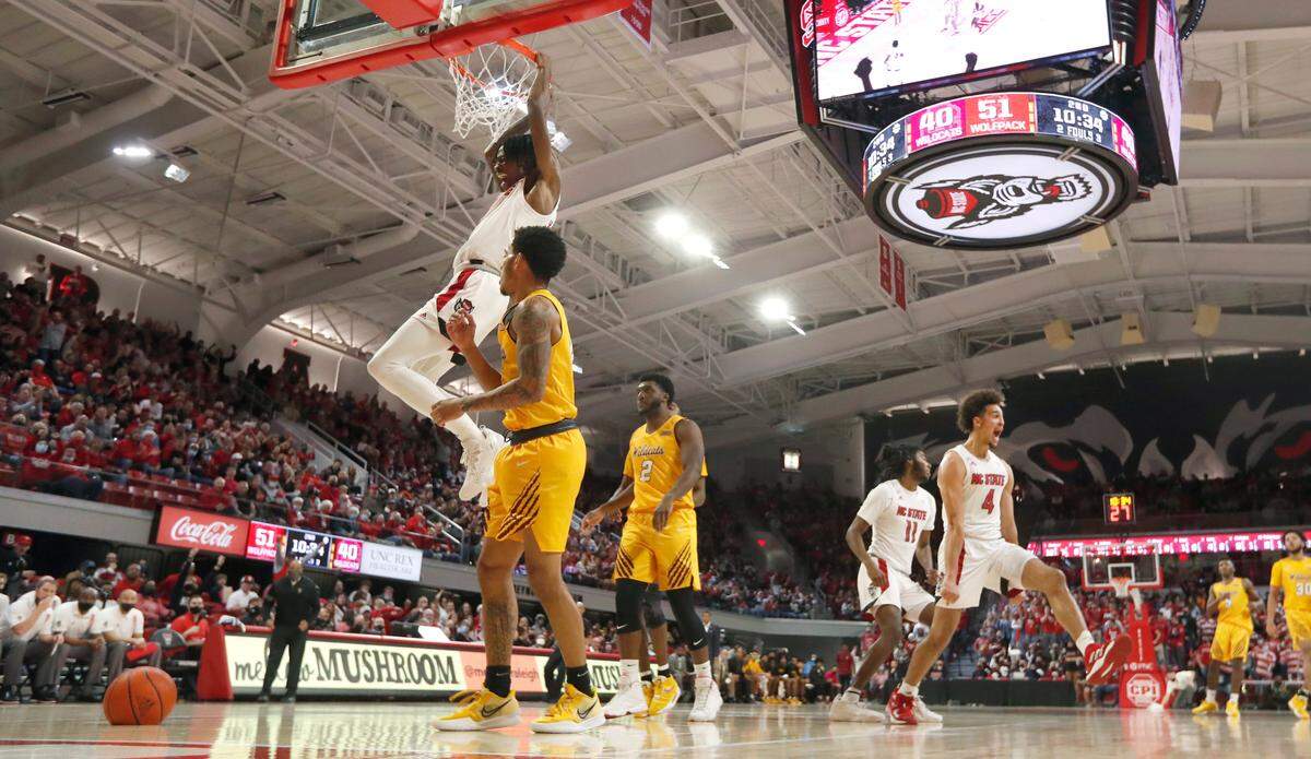 N.C. State’s Jericole Hellems (4), right, reacts as Dereon Seabron (1) slams in two during N.C. State’s 65-48 victory over Bethune-Cookman University at Reynolds Coliseum in Raleigh, N.C., Thursday, December 9, 2021.