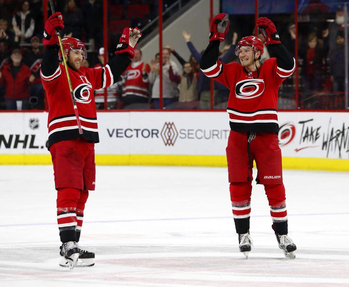 Carolina Hurricanes’ Jaccob Slavin, left, and Brett Pesce, right, start the celebration following the Hurricanes 3-0 win over the Dallas Stars, Saturday, Feb. 16, 2019, in Raleigh, N.C.