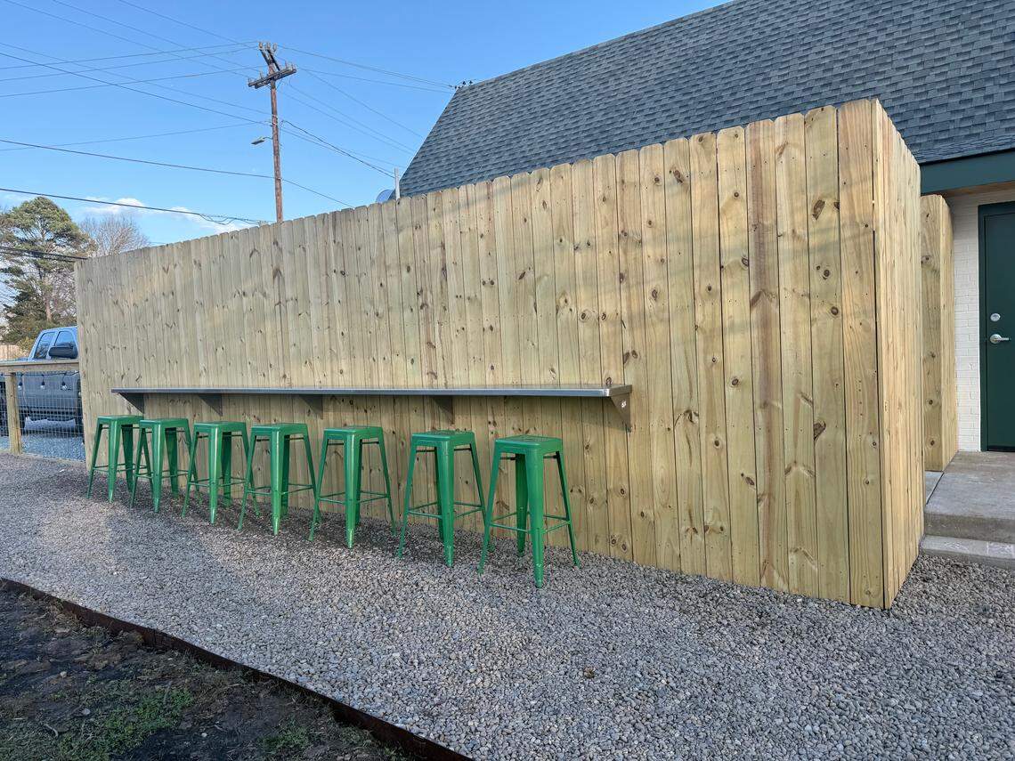 The grassy backyard at Jeans By The Sea also features a row of stools to perch with a Calabash platter.