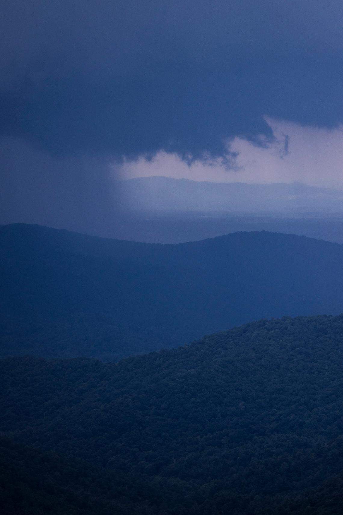 A thunderstorm downpours over a mountain range as seen from a scenic overlook on the Blue Ridge Parkway near Doughton Park in Alleghany County.