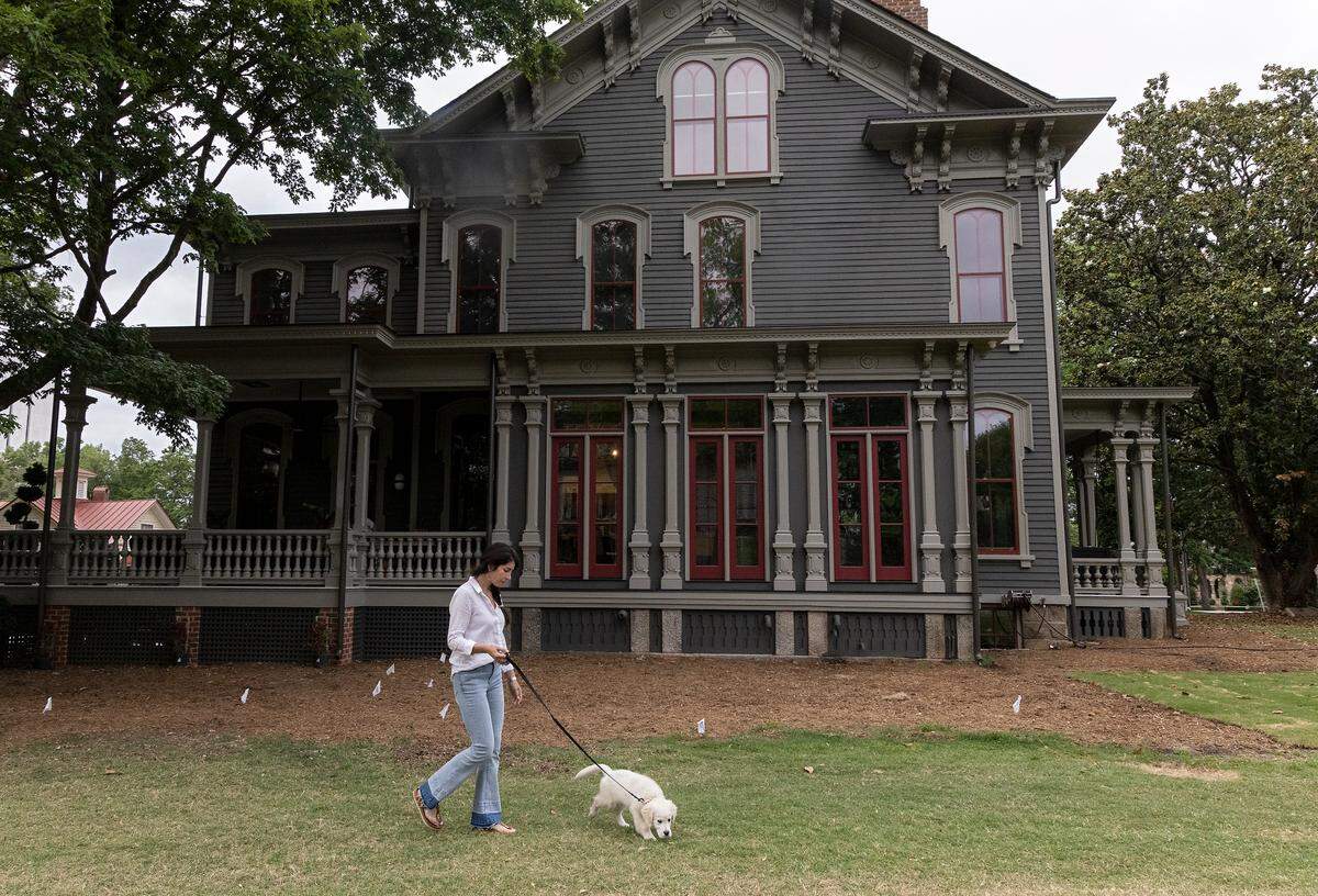 Tina Konidaris walks with Clementine, her family’s English Cream Golden Retriever puppy, outside the Andrews-Duncan House on May 25, 2023. Konidaris and her partner, Jeff Turpin, moved into the 19th-century house in February after working to renovate it for several years.