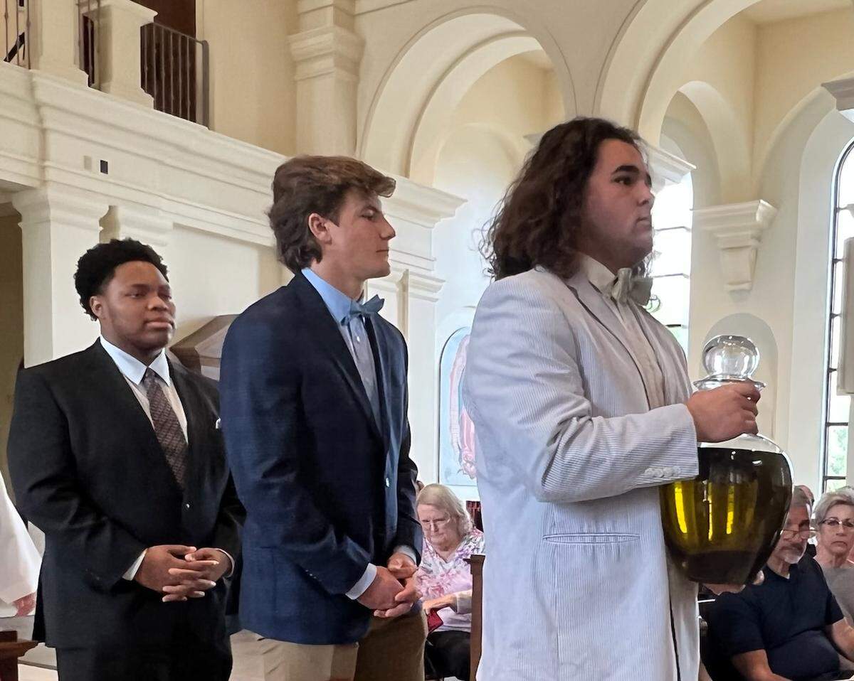 Joey Olivieri, right, followed by Ethan Grace, center, and Jonathan Ward, members of the 2021 Cardinal Gibbons state championship football team, were among Tuesday’s Chrism Mass liturgical ministers at the Diocese of Raleigh Chrism Mass on Tuesday, April 12, at Holy Name of Jesus Cathedral in Raleigh.
