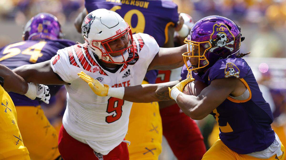 N.C. State defensive end Savion Jackson (9) comes in to stop East Carolina running back Keaton Mitchell (2) during the first half of N.C. Stateís game against ECU at Dowdy-Ficklen Stadium in Greenville, N.C., Saturday, Sept. 3, 2022.