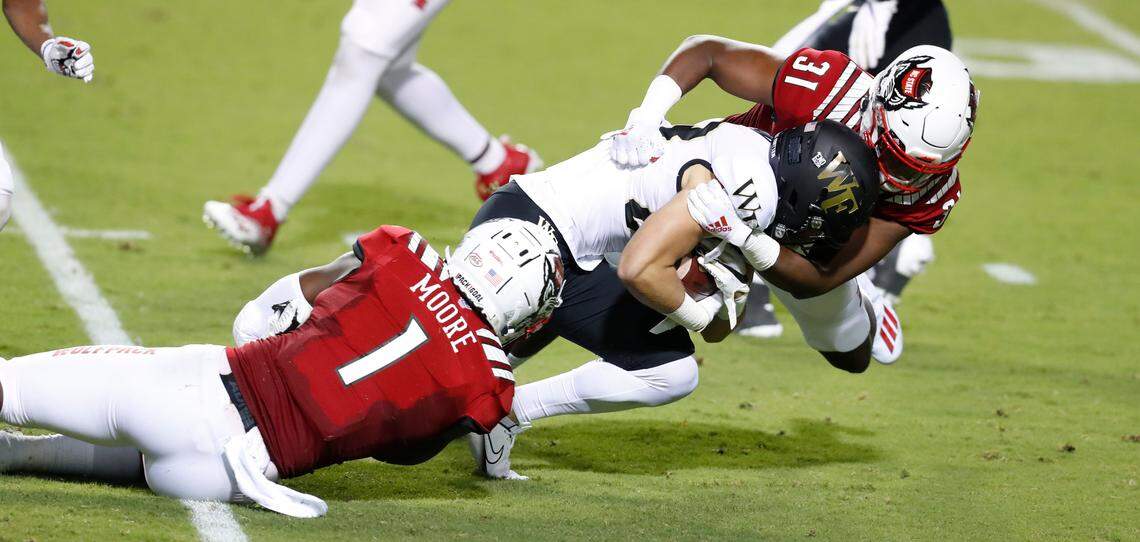 N.C. State linebackers Isaiah Moore (1) and Vi Jones (31) tackle Wake Forest wide receiver Taylor Morin (83) during the first half of N.C. State’s game against Wake Forest at Carter-Finley Stadium in Raleigh, N.C, Saturday, Sept. 19, 2020.