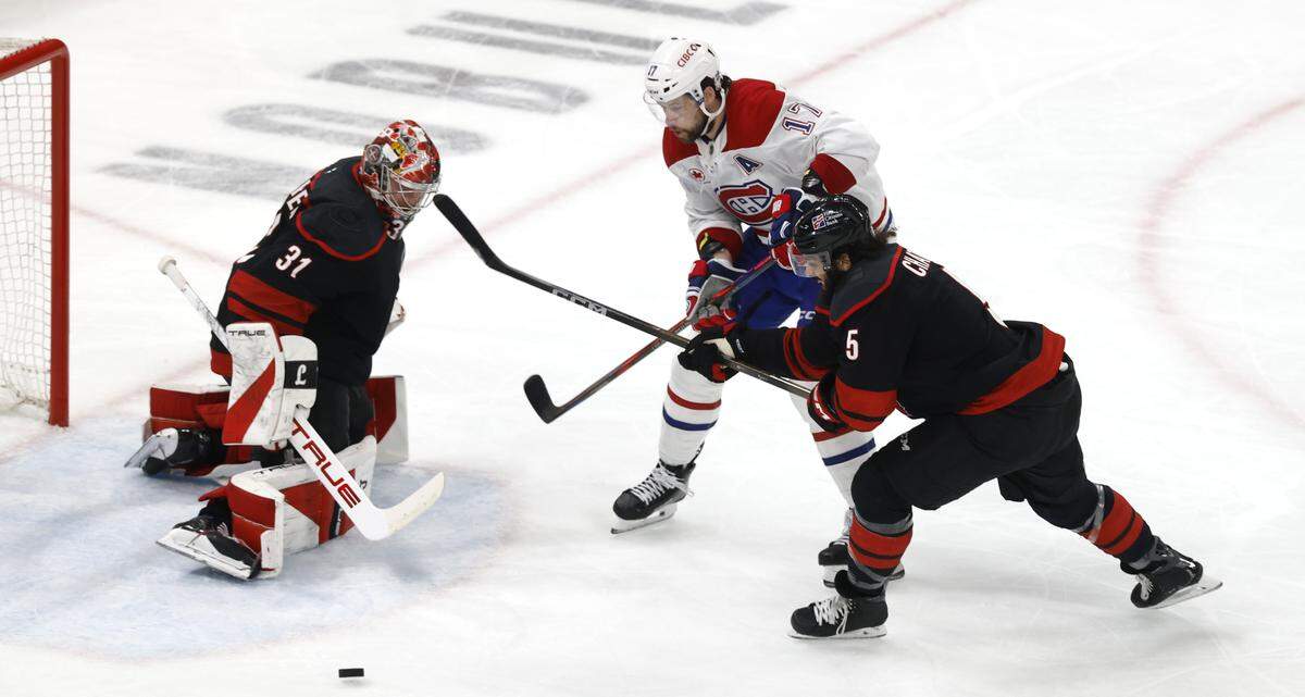 Carolina's Frederik Andersen (31) keeps his eye on the puck as Carolina's Jalen Chatfield (5) and Montréal's Josh Anderson (17) battle during the second period of the Hurricanes’ game against the Canadiens in game one of the Eastern Conference Finals at the Lenovo Center Thursday, May, 21, 2026.